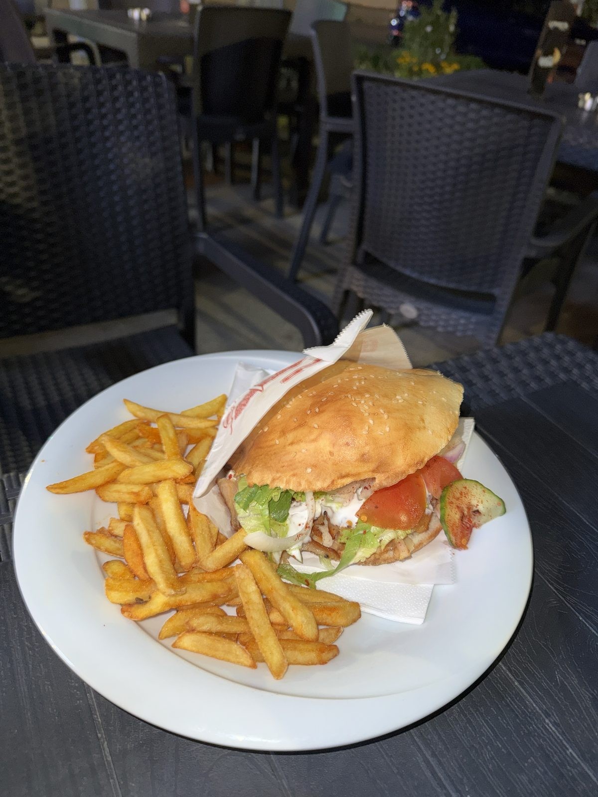 Kebap im Fladenbrot mit knusprigen Pommes auf weißem Teller